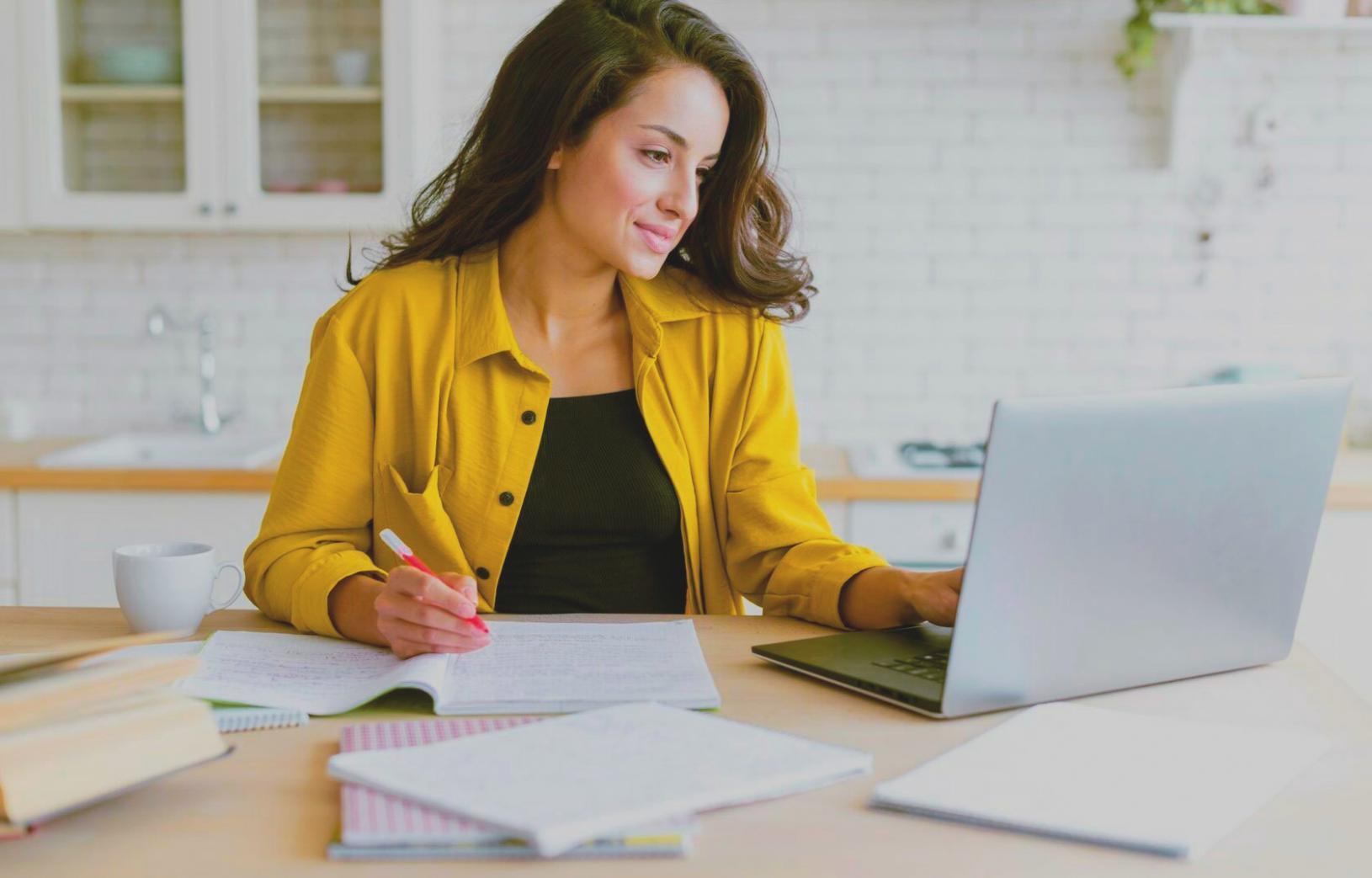 Persona estudiando economía desde su hogar con materiales digitales